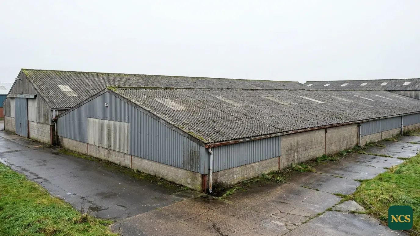 Shot of a large UK industrial estate with ageing cement-fibre profiled roof sheets under an overcast sky
