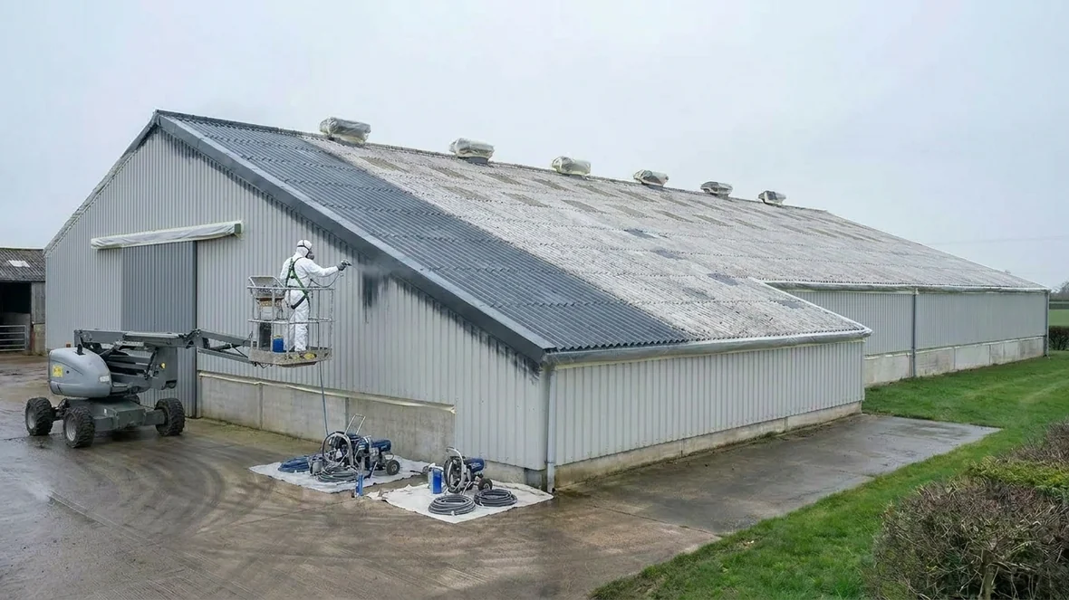 Spraying anthracite grey encapsulation coating on a grain store roof near Taunton