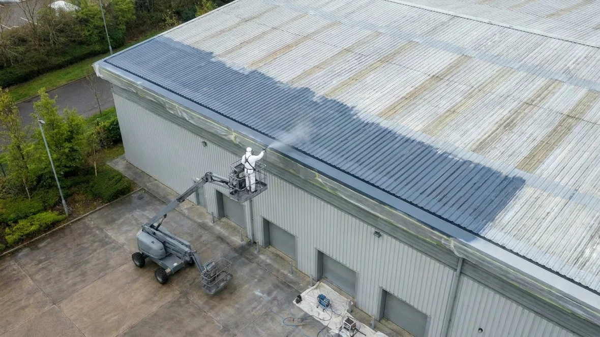 Airless spraying Slate Blue RAL 5008 during warehouse roof coating near Huddersfield