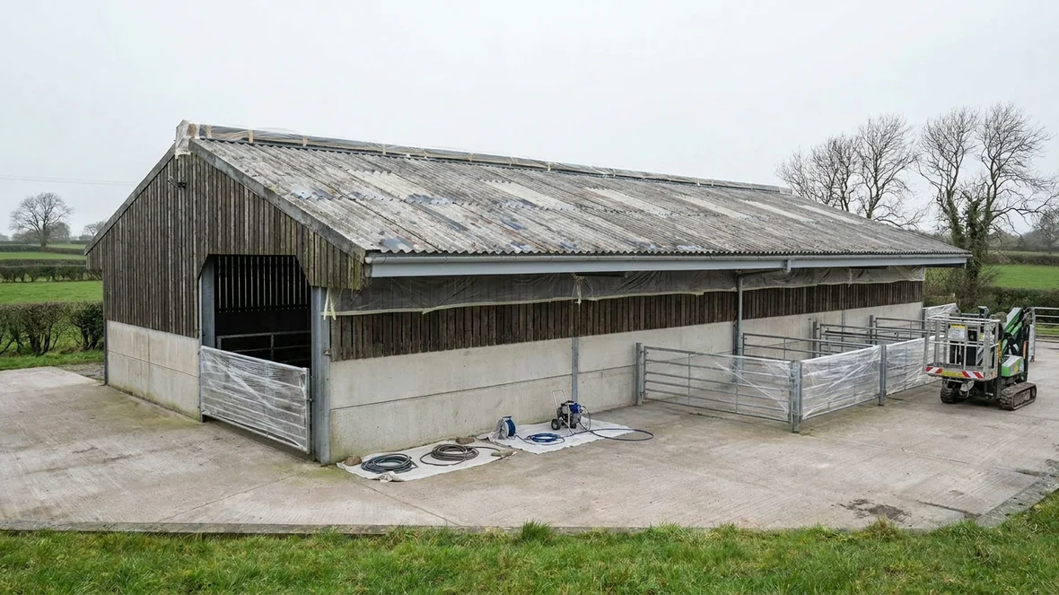 Masked ridge and lined box gutter before roof coating on a livestock building near York