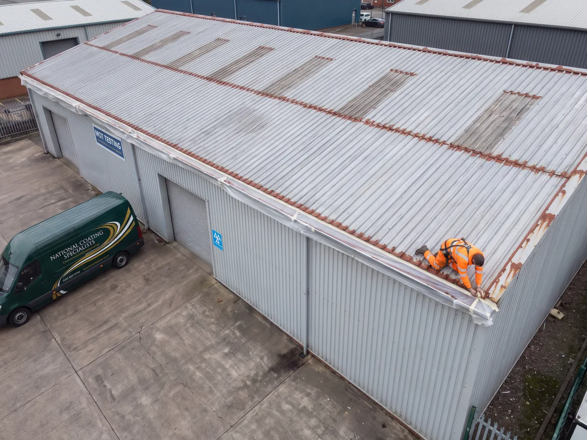 Masked gutter line and primed fixings on an MOT garage roof near Swindon