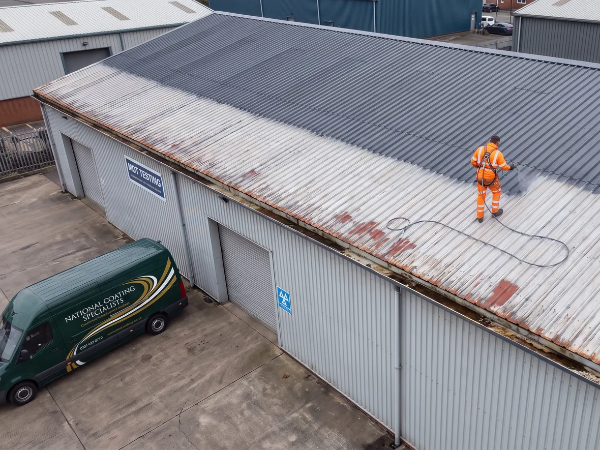 Spraying anthracite roof coating on an MOT garage near Swindon
