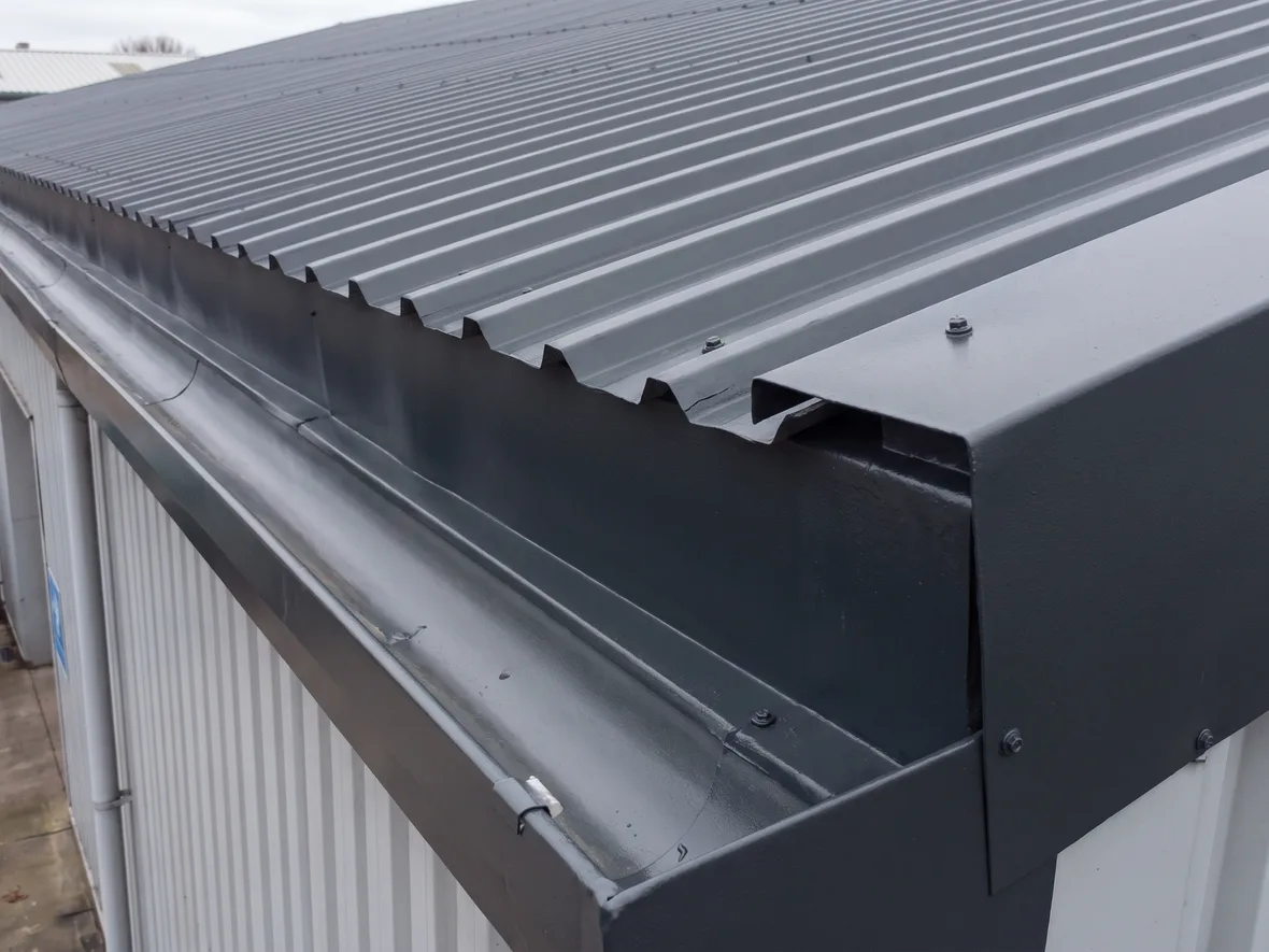Coated roof edge detail at the gutter on an MOT garage near Swindon