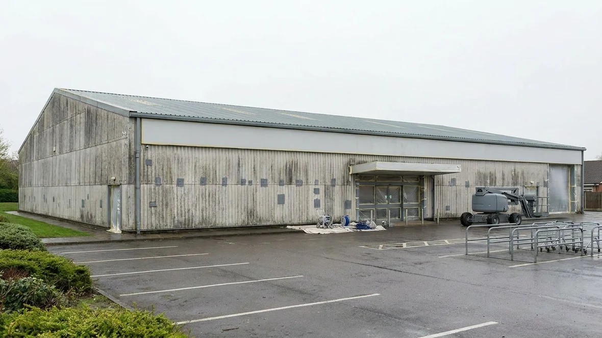 Masking windows and signage during exterior wall coating on a supermarket near Derby