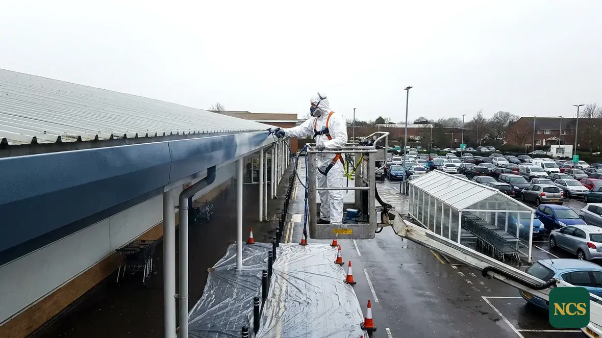 Operative lining an industrial box gutter at eaves level