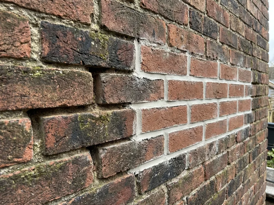 Careful repointing in progress on a large industrial unit's brick facade.