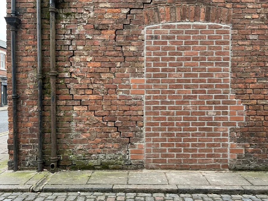 Close-up showing heavily spalled bricks before replacement.