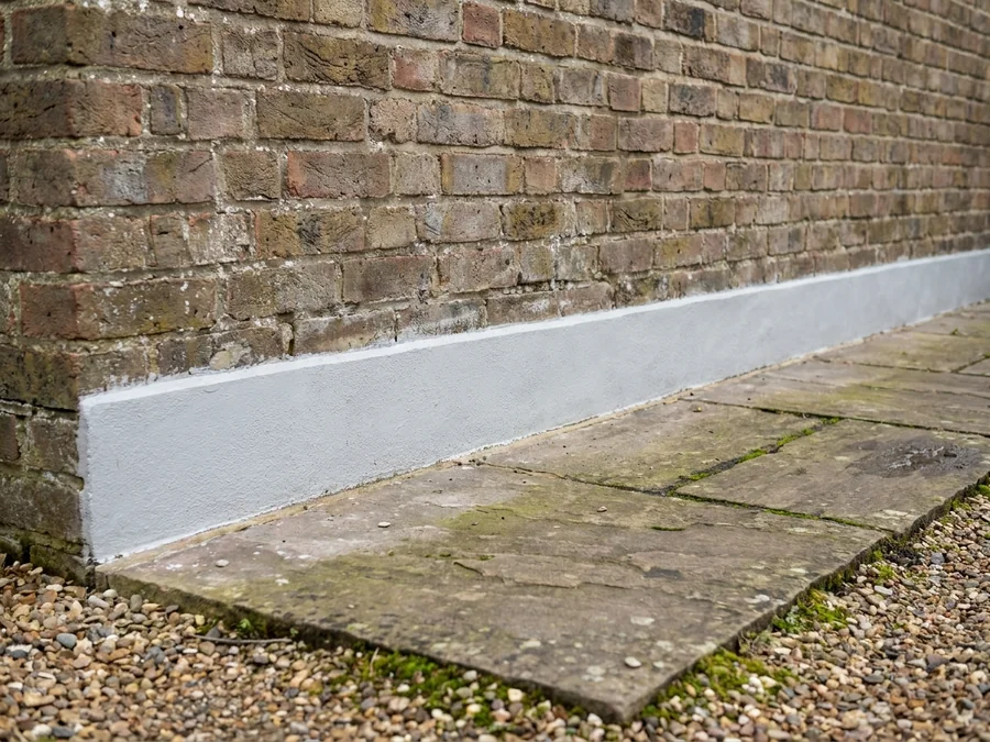 External masonry before and after application of a protective waterproof coating on a commercial unit.
