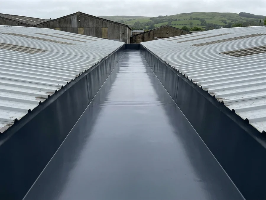 A refurbished gutter system on a large agricultural building.